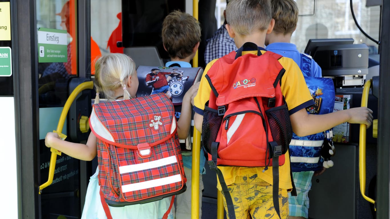 Kinder steigen in einen Bus (Archivbild): In Bayern ist ein Schulbus in Flammen aufgegangen.