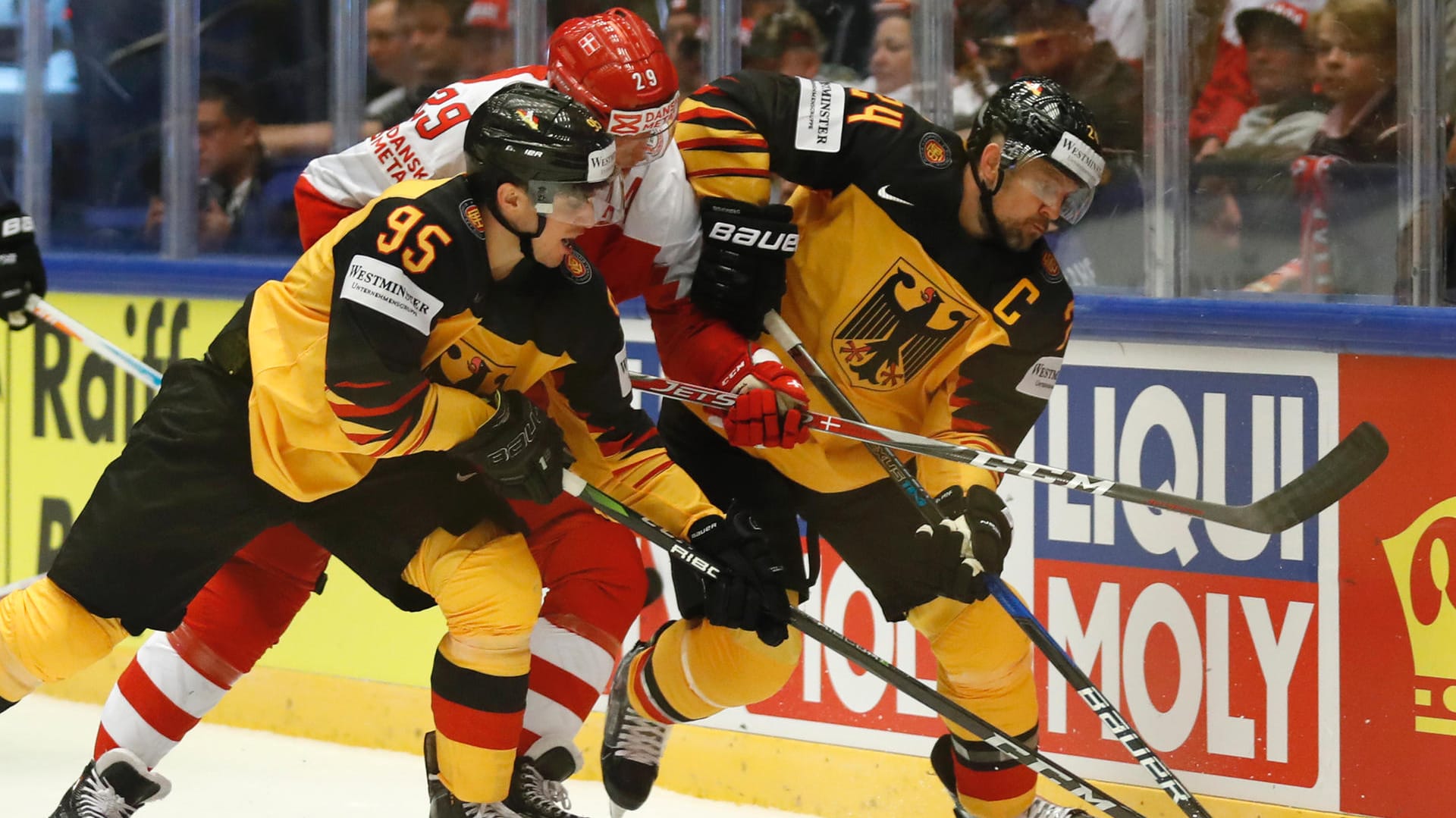 Deutschlands Dennis Seidenberg (rechts) und Frederik Tiffels kämpfen mit Dänemarks Morten Madsen (M) um den Puck.