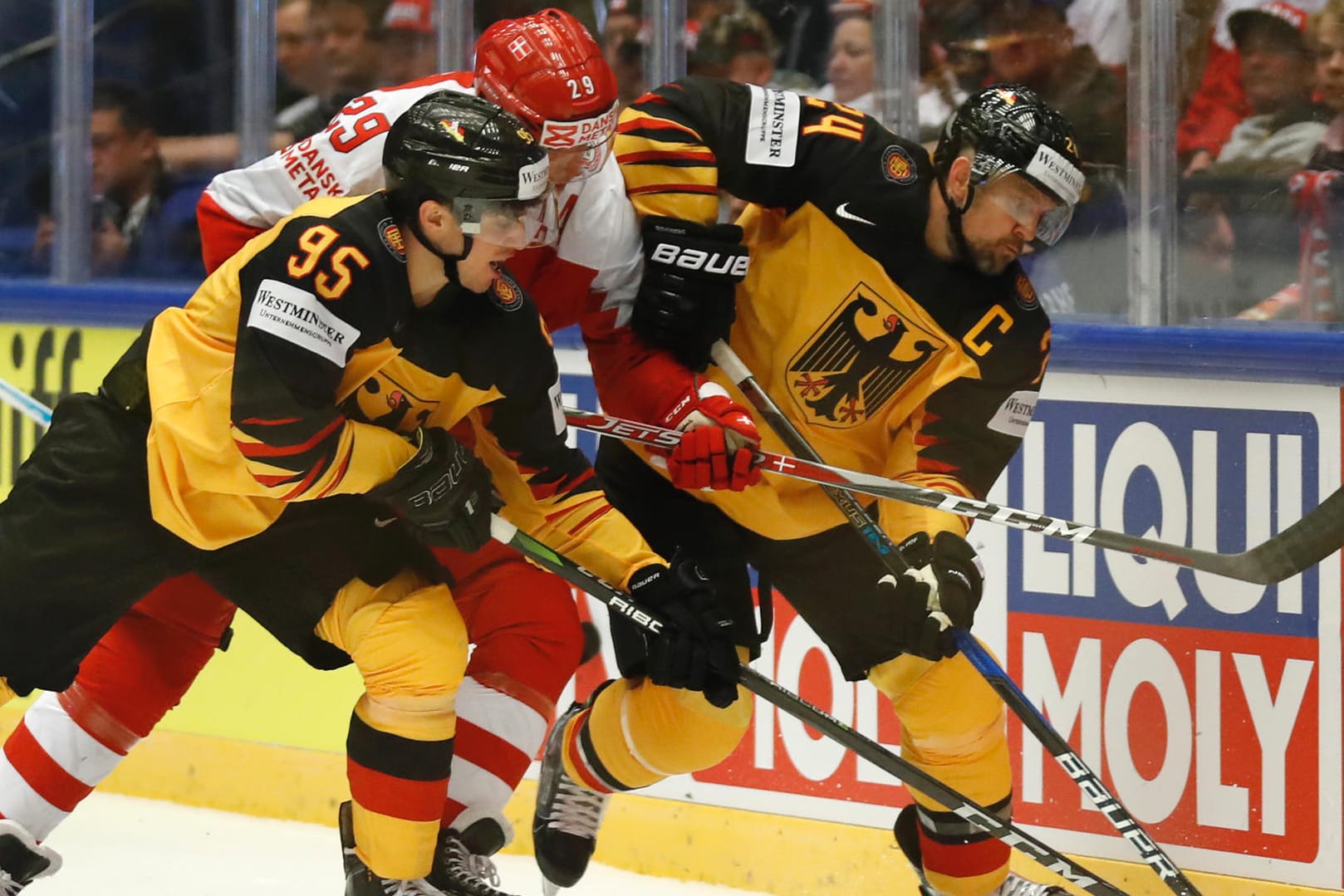 Deutschlands Dennis Seidenberg (rechts) und Frederik Tiffels kämpfen mit Dänemarks Morten Madsen (M) um den Puck.