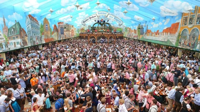 Besucher feiern in einem Festzelt auf dem Oktoberfest.