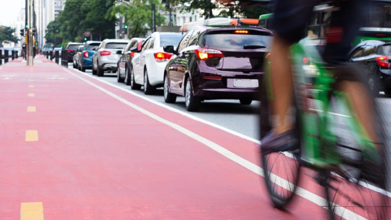 Radfahrer und Autos im Straßenverkehr: Die Fahrt zum Arbeitsplatz wird pauschal mit 30 Cent pro gefahrenen Kilometer steuerlich angerechnet. Doch auch da gibt es Feinheiten, die es zu beachten gilt.