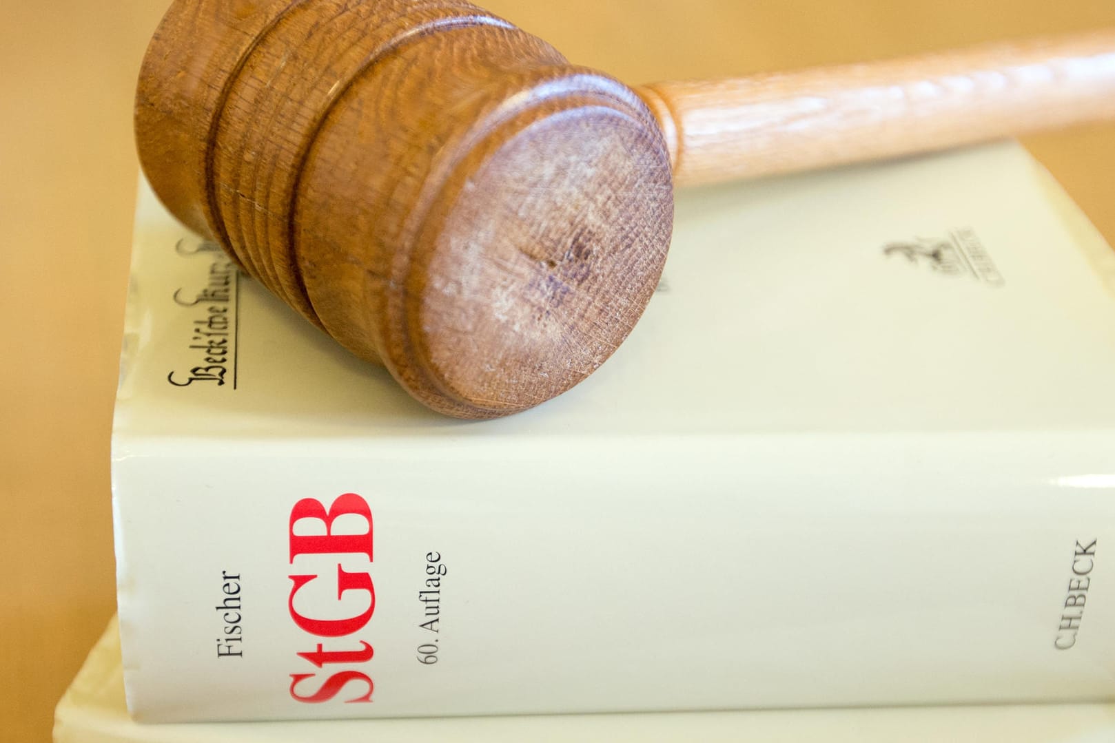 Ein Richterhammer und ein Strafgesetzbuch liegen auf einem Tisch: Mann will per Gericht drei Cent eintreiben, scheitert jedoch.