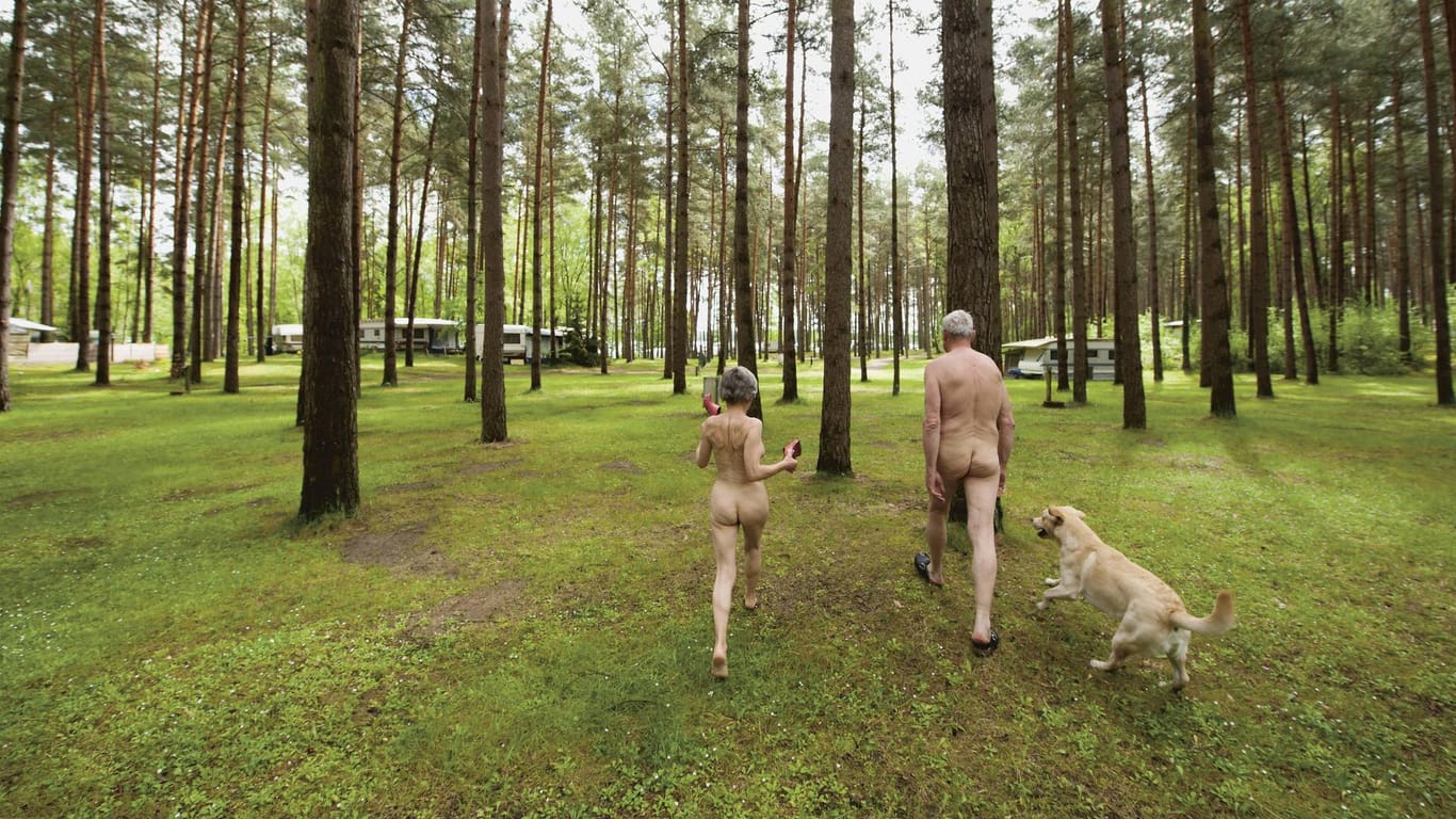 Nacktcamper mit Hund im Wald auf der FKK Campinganlage Haveltourist an der Mecklenburgischen Seenplatte