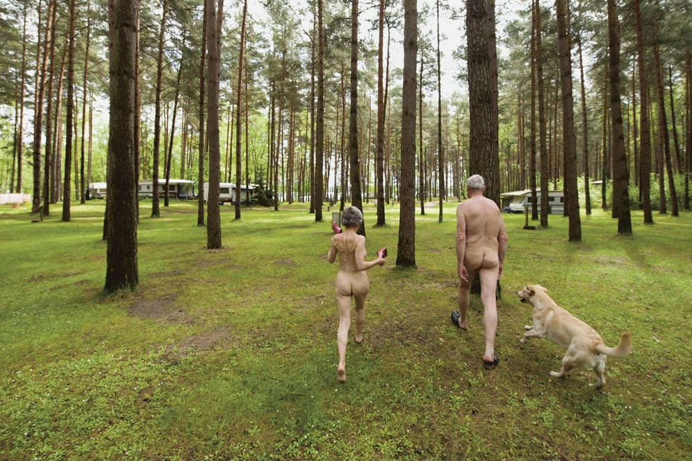 Nacktcamper mit Hund im Wald auf der FKK Campinganlage Haveltourist an der Mecklenburgischen Seenplatte