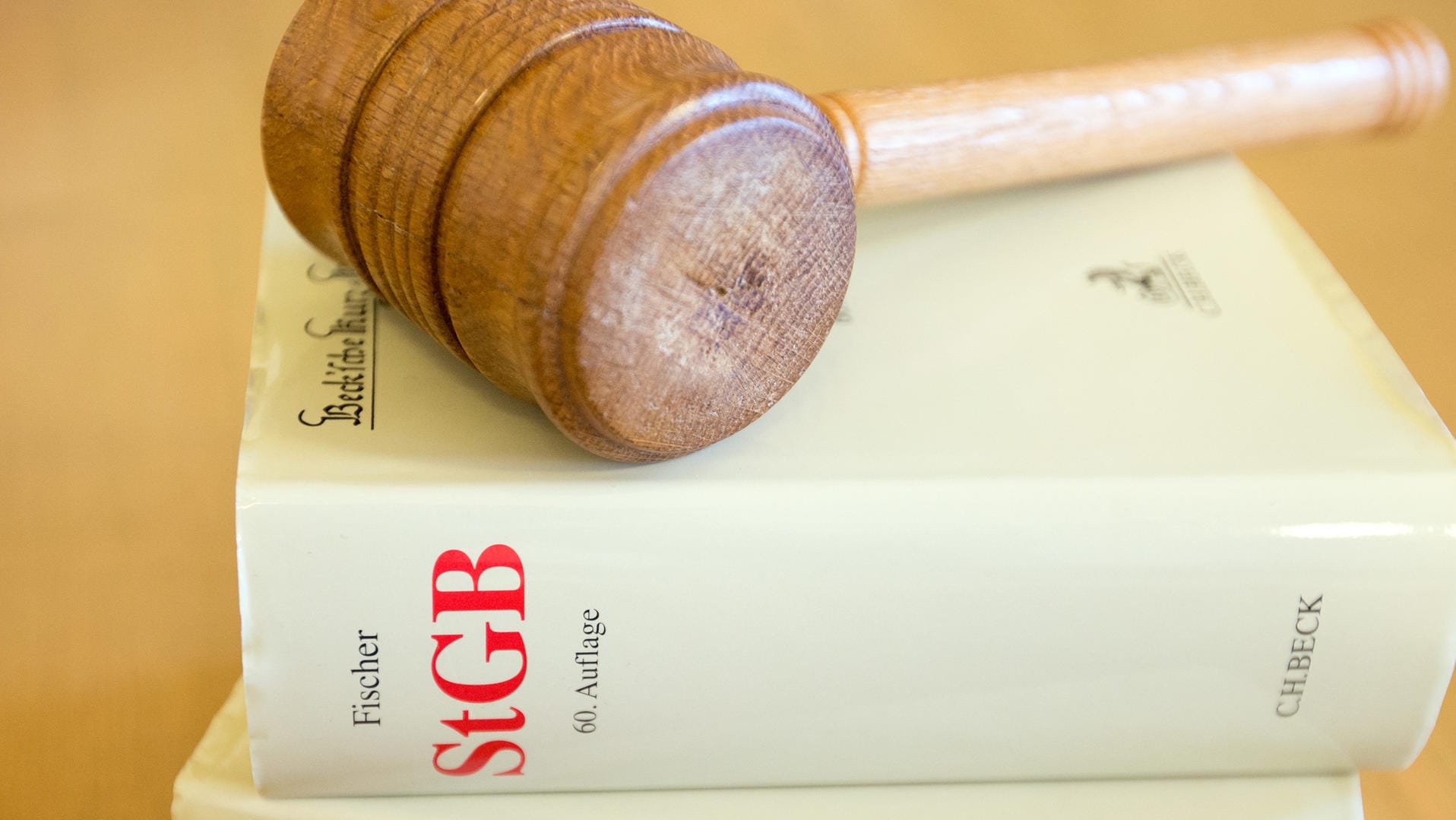 Ein Richterhammer und ein Strafgesetzbuch liegen auf einem Tisch: Prozess gegen mutmaßlichen Schleuser eröffnet Ein Richterhammer und ein Strafgesetzbuch liegen auf einem Tisch: Prozess gegen mutmaßlichen Schleuser eröffnet
