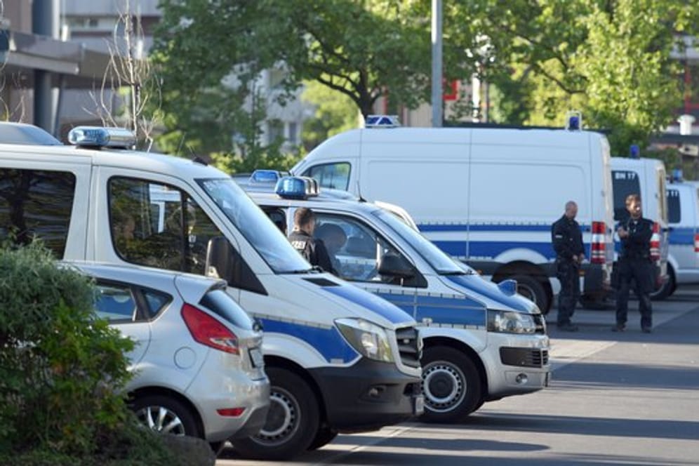 Fahrzeuge der Polizei stehen im Bonner Stadtteil Tannenbusch auf einem Parkplatz.
