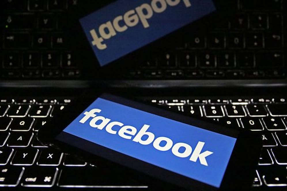 Smartphone mit dem Logo von Facebook liegt auf Tastatur