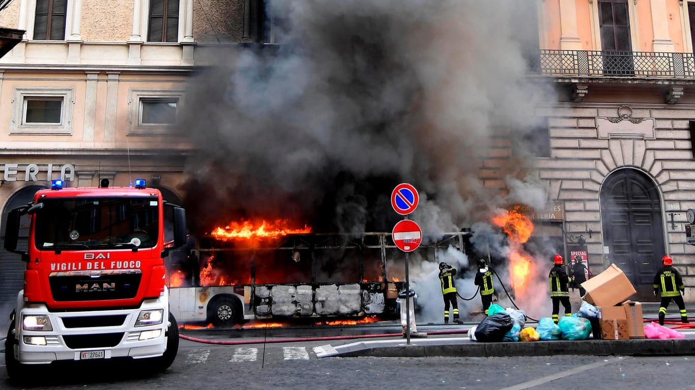 Feuerwehrmänner versuchen einen Linienbus in Rom zu löschen: Das Fahrzeug ging in unmittelbarer Nähe des berühmten Trevi-Brunnens in Flammen auf.