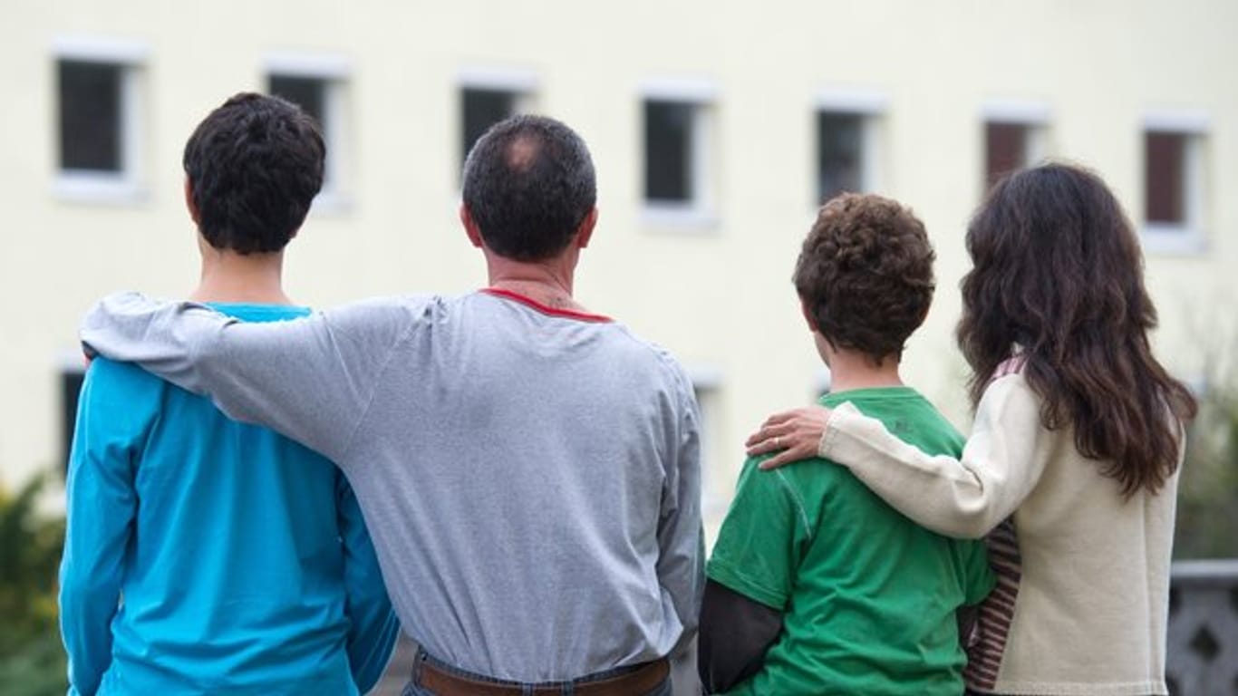 Eine syrische Familie sitzt vor einem Wohnheim der Zentralen Ausländerbehörde des Landes Brandenburg.