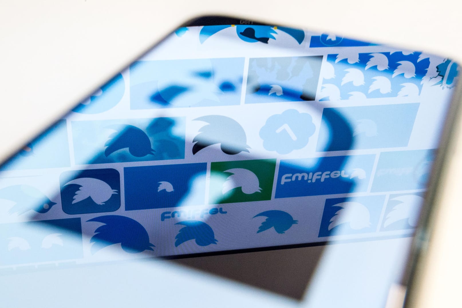 In einem Smartphone-Display spiegelt sich das Twitter-Logo: Nicht nur für die Internetriesen ändern sich die Datenschutzregeln, auch für Verbraucher.