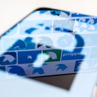In einem Smartphone-Display spiegelt sich das Twitter-Logo: Nicht nur für die Internetriesen ändern sich die Datenschutzregeln, auch für Verbraucher.