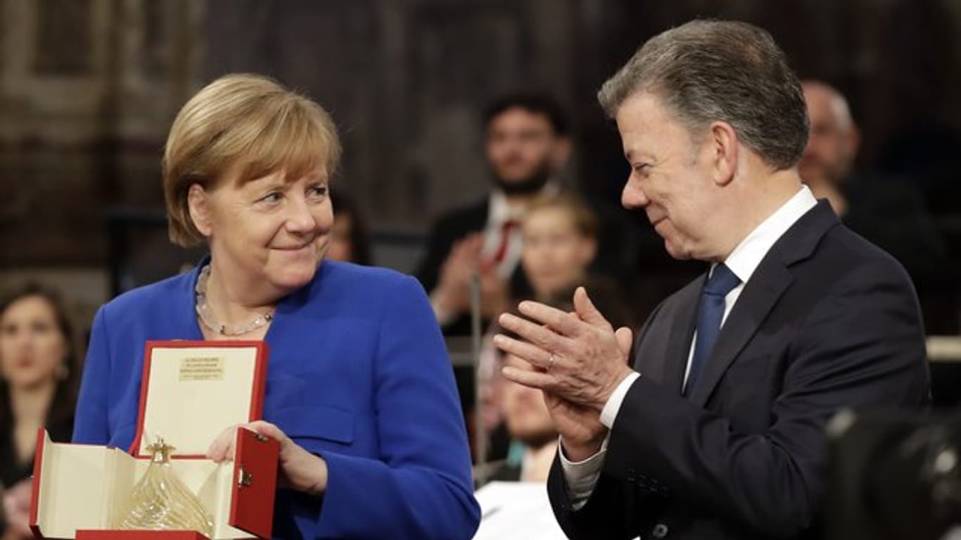 Bundeskanzlerin Angela Merkel hält das Friedenslicht des heiligen Franziskus.