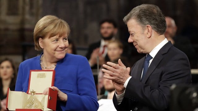 Bundeskanzlerin Angela Merkel hält das Friedenslicht des heiligen Franziskus. Bundeskanzlerin Angela Merkel hält das Friedenslicht des heiligen Franziskus.