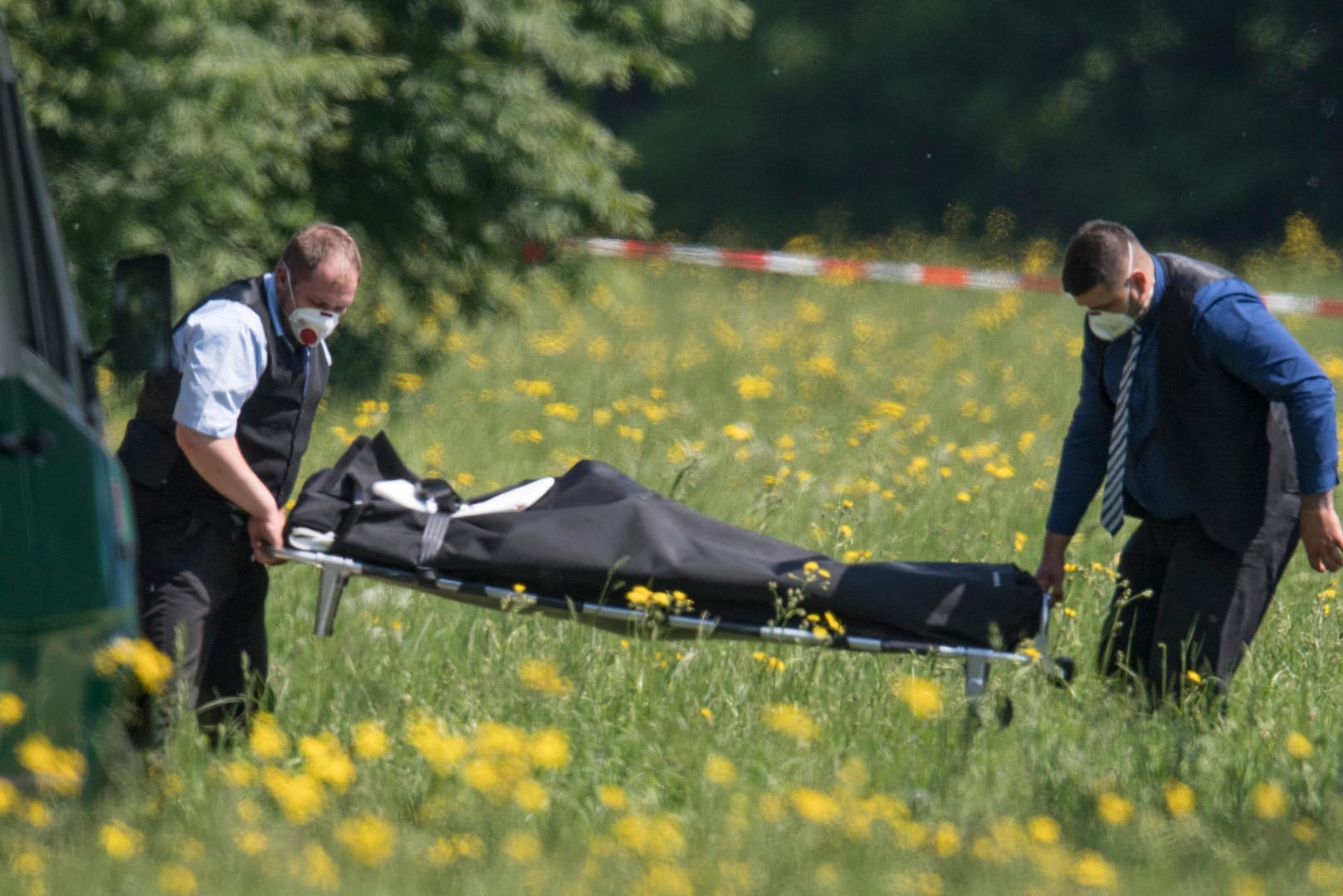 Bestatter transportieren die Leiche ab: Die getötete Frau war wegen einer Falschaussage angeklagt worden.