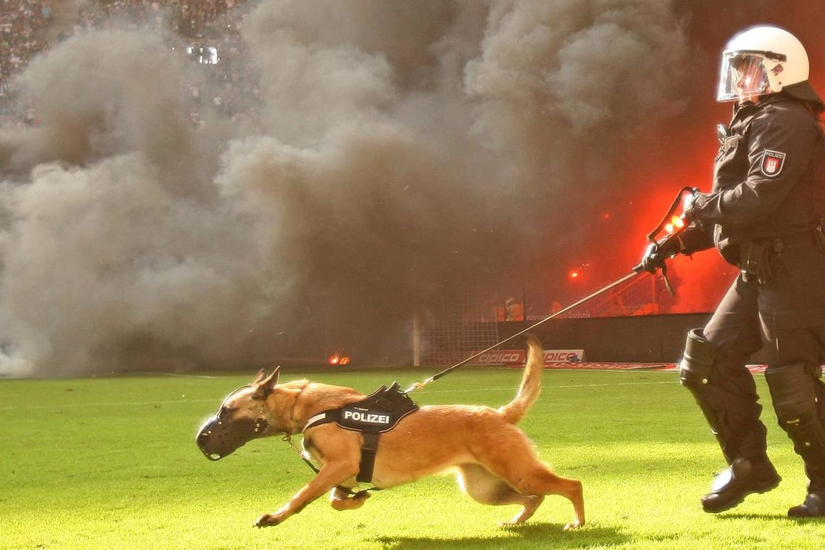 Eine Polizistin stürmt auf den Rasen des Volksparkstadions: Zwischenzeitlich fürchteten die Sicherheitskräfte einen Platzsturm.