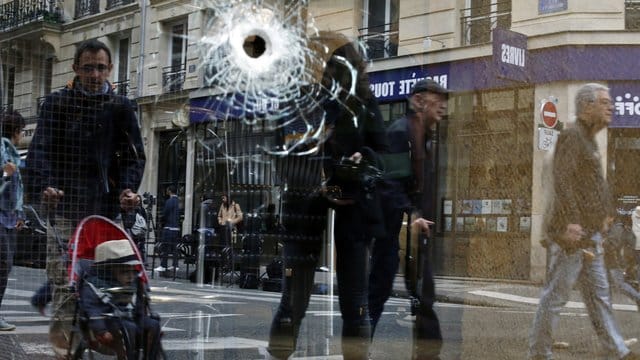 Ein Einschussloch ist nahe der Stelle, an dem ein Angreifer am Tag zuvor von der Polizei erschossen wurde, im Fenster eines Cafés zu sehen.