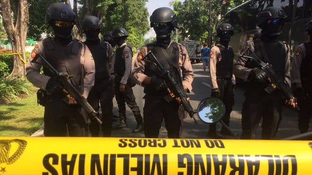 Polizisten stehen hinter einer Absperrung vor der Kirche Santa Maria in Surabaya. Polizisten stehen hinter einer Absperrung vor der Kirche Santa Maria in Surabaya.