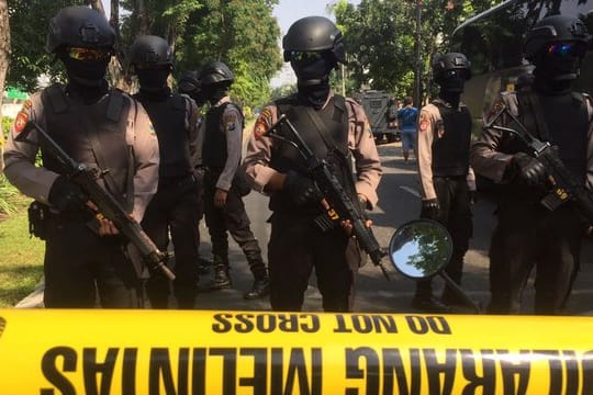 Polizisten stehen hinter einer Absperrung vor der Kirche Santa Maria in Surabaya.