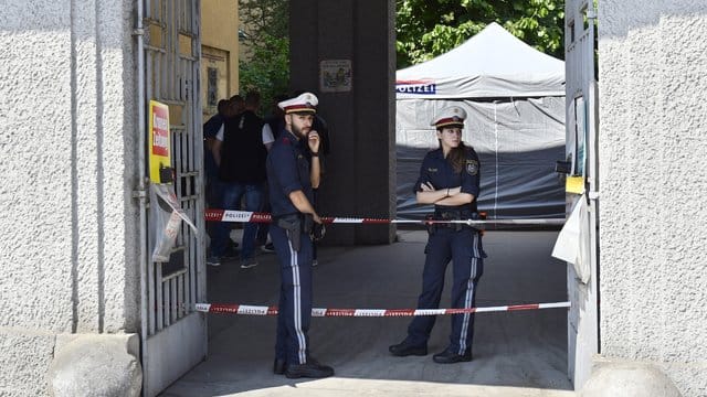 Polizisten stehen vor einer Wohnhausanlage, nachdem der Leichnam eines Mädchens in einem Müllcontainer entdeckt wurde. Polizisten stehen vor einer Wohnhausanlage, nachdem der Leichnam eines Mädchens in einem Müllcontainer entdeckt wurde.