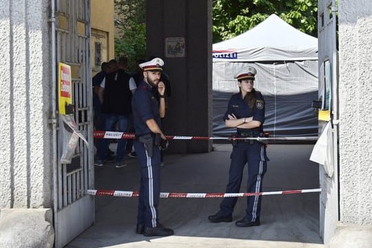 Polizisten stehen vor einer Wohnhausanlage, nachdem der Leichnam eines Mädchens in einem Müllcontainer entdeckt wurde.