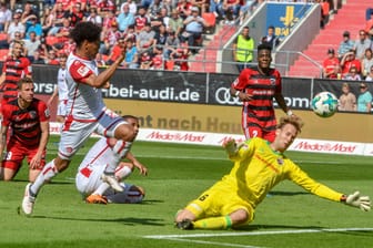 Phillipp Mwene von Kaiserslautern (l) trifft zum 0:1 ins Tor von Torwart Marco Knaller von Ingolstadt