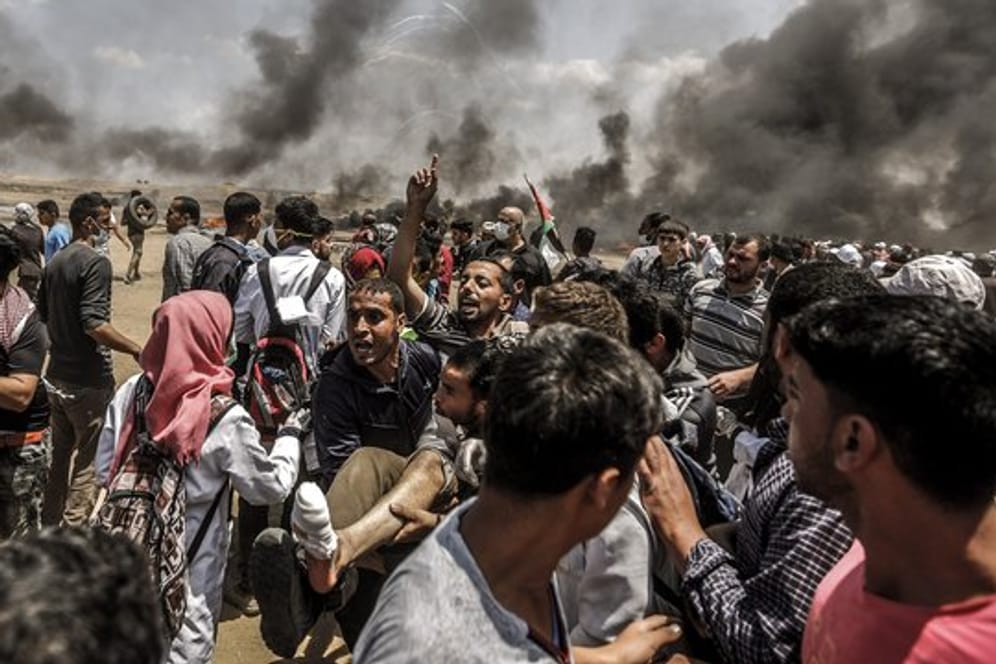 Palästinenser tragen einen bei den Auseinandersetzungen mit israelischen Truppen verletzten Demonstranten.
