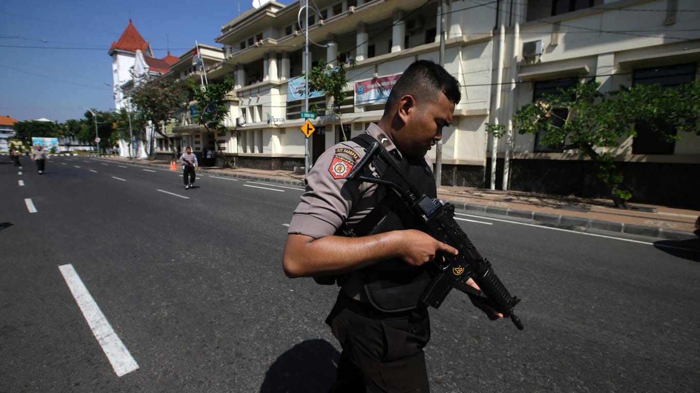 Polizisten sperren nach einem Anschlag auf die Polizeizentrale eine Straße ab: Einen Tag nach den Selbstmordattentaten auf christliche Kirchen ist es zu einem weiteren Anschlag in Surabaya gekommen.