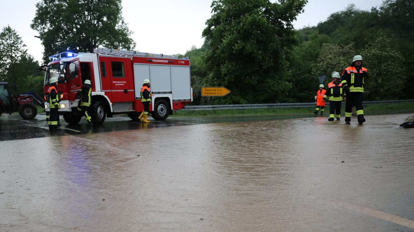 Ein Feuerwehrwagen steht hinter einem überschwemmten Teilstück der Bundesstraße 49: Heftige Frühlingsgewitter haben im Vogelsbergkreis zu mehr als 120 Feuerwehreinsätzen geführt.