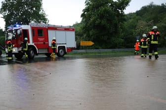 Ein Feuerwehrwagen steht hinter einem überschwemmten Teilstück der Bundesstraße 49: Heftige Frühlingsgewitter haben im Vogelsbergkreis zu mehr als 120 Feuerwehreinsätzen geführt.