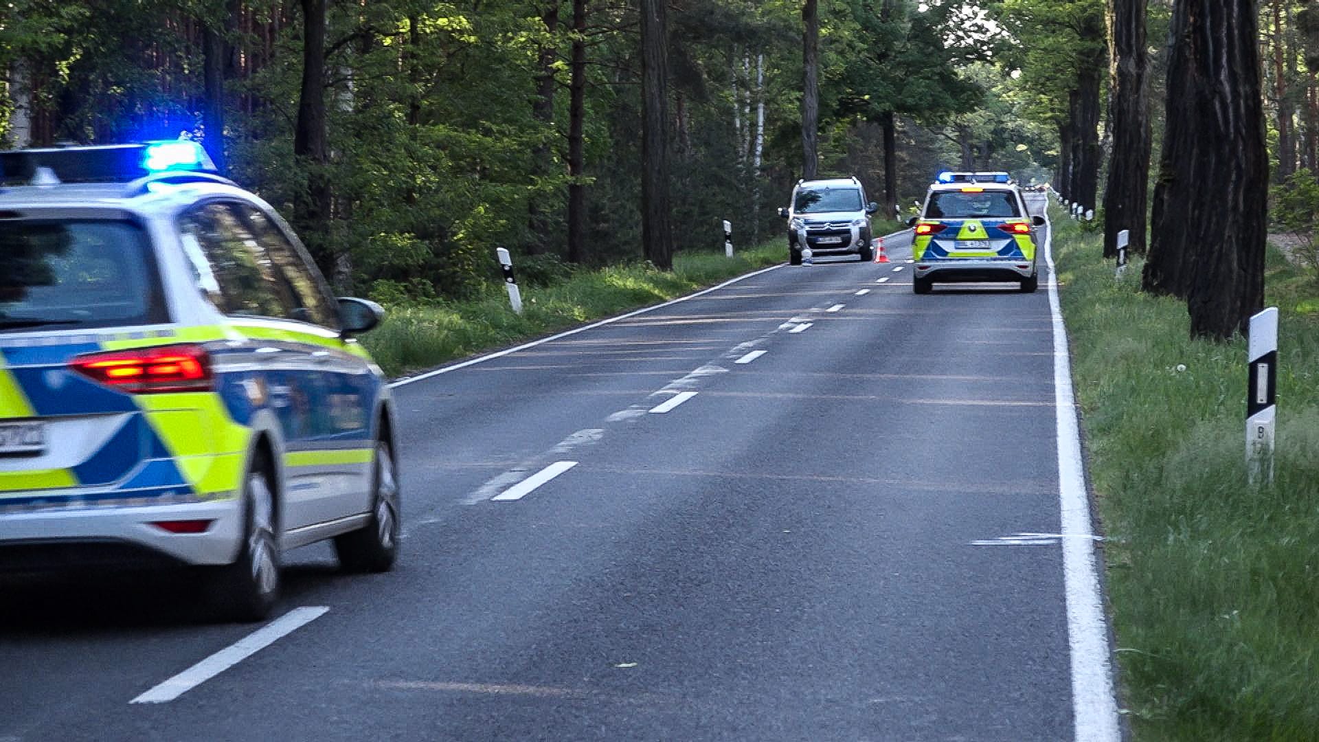 Polizeifahrzeuge sichern die Unfallstelle auf der B 179 bei Groß Köris: Dort war am Sonntag ein 81-Jähriger mit dem Auto in eine Gruppe von vier Radfahrern gerast.