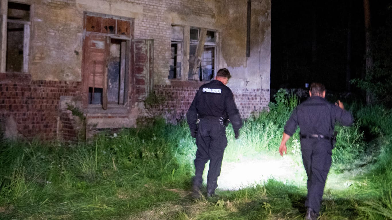 Polizisten suchen nach dem Einsatz das ehemalige Kasernengelände in Könisgbruck ab: Der Sportschütze hatte von einem Dachgeschoss aus auf die Beamten geschossen.