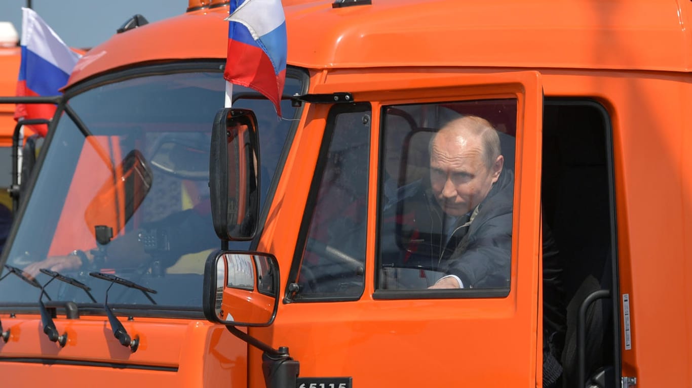 Wladimir Putin bei der Eröffnung der Brücke zur Krim: Der Staatschef setzte sich selbst ans Steuer eines orangen Lastwagens und fuhr die 19 Kilometer lange Strecke ab.