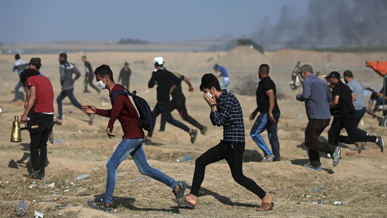 Palästinensische Protestierende: Sie laufen auf der Suche nach Deckung durch Tränengas, das von israelischen Truppen während eines Protestes an der israelischen Grenze des Gazastreifens abgefeuert wurde.