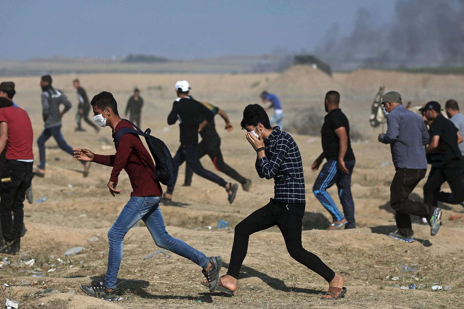 Palästinensische Protestierende: Sie laufen auf der Suche nach Deckung durch Tränengas, das von israelischen Truppen während eines Protestes an der israelischen Grenze des Gazastreifens abgefeuert wurde.