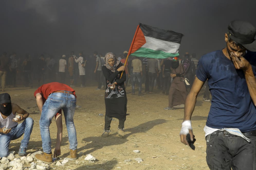 Ein palästinensischer Protestierender schwenkt eine palästinensische Flagge: Die Situation an der Gazagrenze ist weiterhin angespannt.