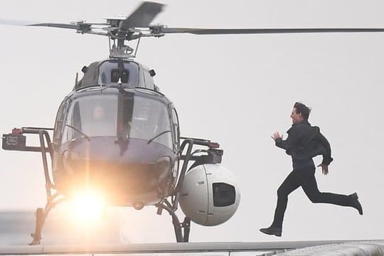 Tom Cruise rennt während der Dreharbeiten auf einen Helikopter zu.