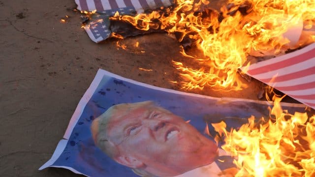 Palästinensische Demonstranten verbrennen Poster mit dem Konterfei des US-Präsidenten Trump. Palästinensische Demonstranten verbrennen Poster mit dem Konterfei des US-Präsidenten Trump.
