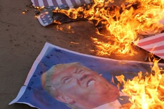 Palästinensische Demonstranten verbrennen Poster mit dem Konterfei des US-Präsidenten Trump.