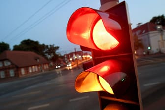 Rotes und gelbes Licht zeigt eine Ampel an einer Kreuzung an: Wer über rot fährt, kann seinen Führerschein verlieren.
