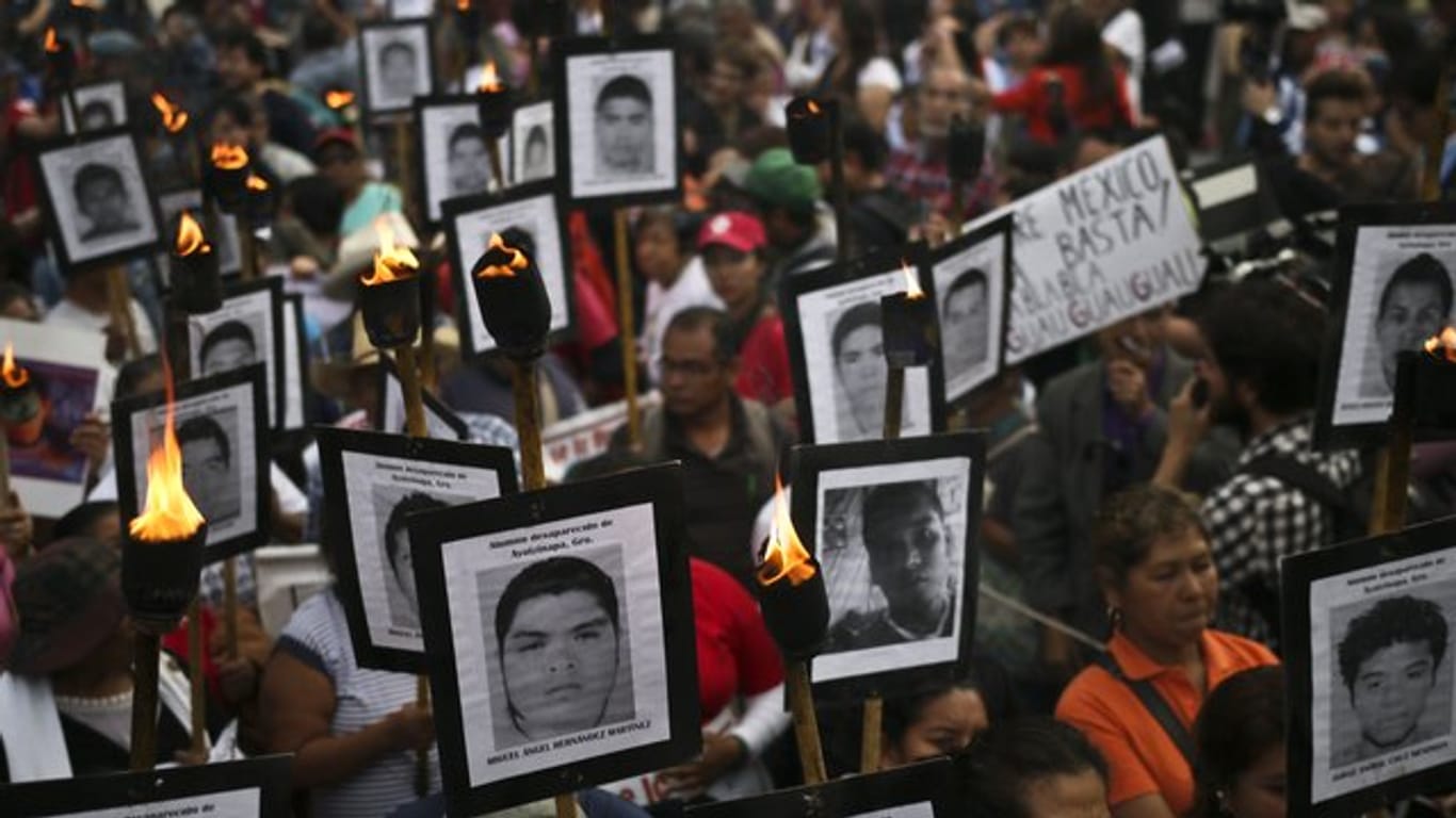 Angehörige halten 2016 bei einer Demonstration Bilder der 43 vermissten Studenten hoch.