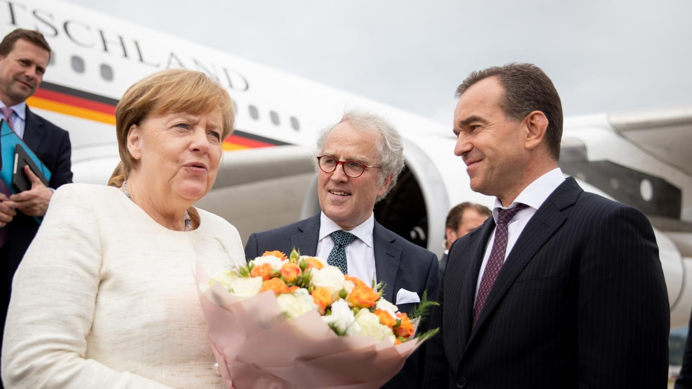 Merkel, der Gouverneur der Region Krasnodar, Weniamin Iwanowitz Kodratjew (r) und der deutschen Botschafter Rüdiger Freiherr von Fritsch (M) in Sotschi: Auch hier gab es schon Blumen.