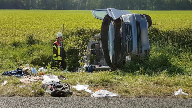 Ein Feuerwehrmann steht an der A31 zwischen Ochtrup und Heek im Kreis Borken am Wrack eines Fahrzeugs: Bei einem schweren Unfall sind hier vier Menschen schwer verletzt worden und eine Frau ums Leben gekommen.