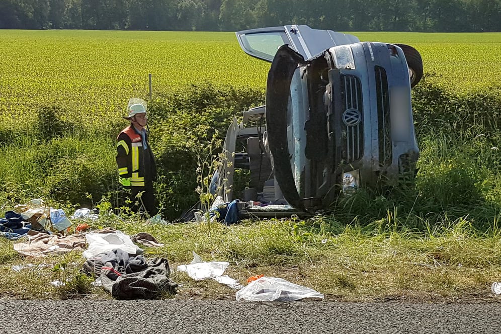 Ein Feuerwehrmann steht an der A31 zwischen Ochtrup und Heek im Kreis Borken am Wrack eines Fahrzeugs: Bei einem schweren Unfall sind hier vier Menschen schwer verletzt worden und eine Frau ums Leben gekommen.
