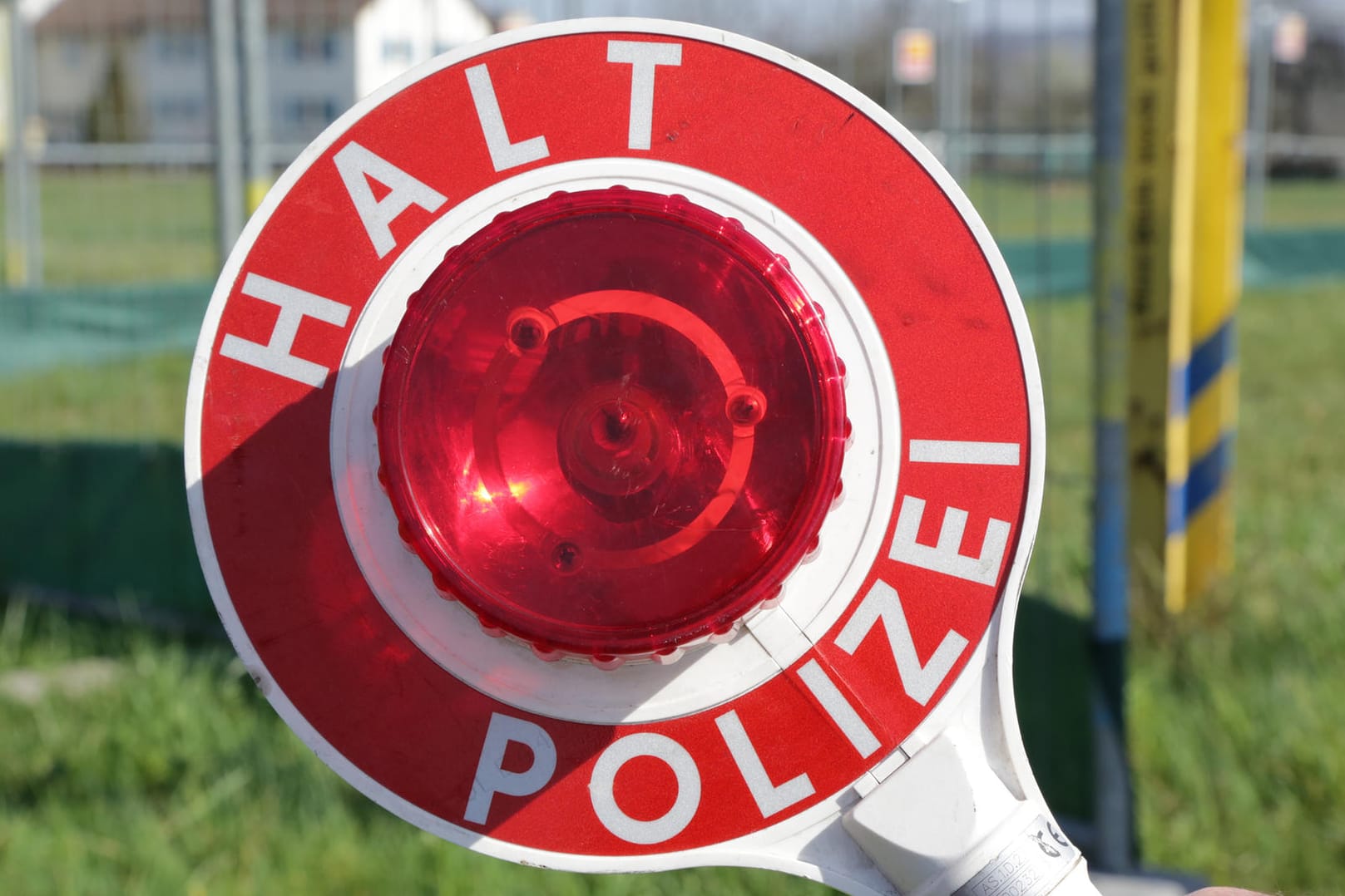 Polizist mit einer Kelle in der Hand: Polizei stoppt Trunkenfahrten – erst vom Sohn und dann vom Vater.