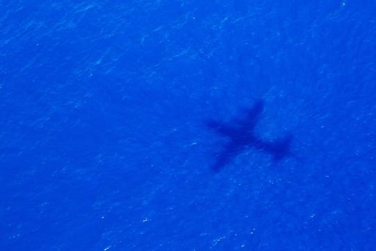 Ein Schatten eines Fliegers über dem Indischen Ozean, der nach dem Malaysia Airways Flight MH370 sucht.