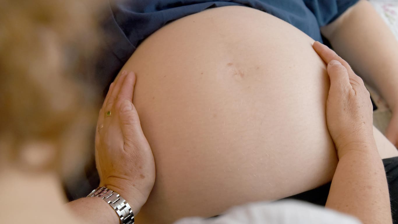 Eine Hebamme tastet den Bauch einer Schwangeren ab: Schlechte Bezahlung, Arbeitsbelastung und hohe Haftpflichtprämien sorgen für einen Mangel an Geburtshelfern.
