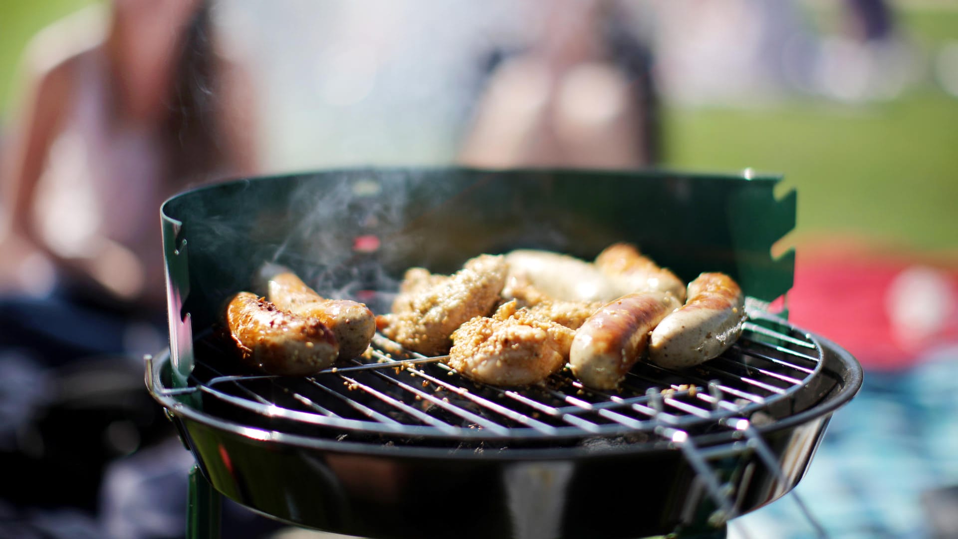 Würstchen liegen auf einem Grill: Wenn Fleischsaft in die Glut tropft, entstehen Giftstoffe.