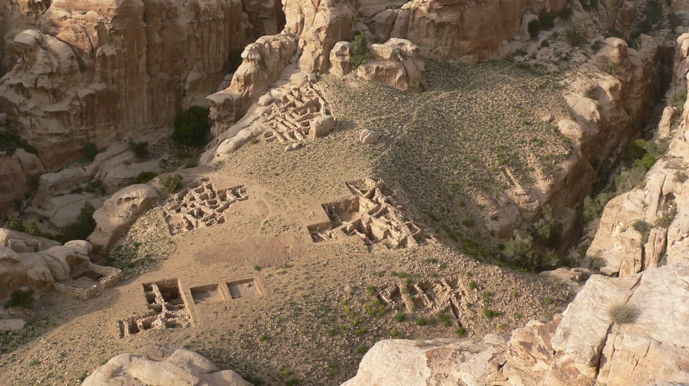 Spektakuläre Lage und Ausgrabungsareale des über 9000 Jahre alten Dorfs von Baʻja, fast unzugänglich in der südjordanischen Bergwelt von Petra gelegen.