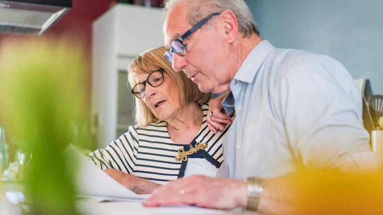 Älteres Ehepaar beim Lesen von Unterlagen: Mit einem Einkommen aus der gesetzlichen Rentenversicherung finanzieren viele Ruheständler ihren Lebensabend.