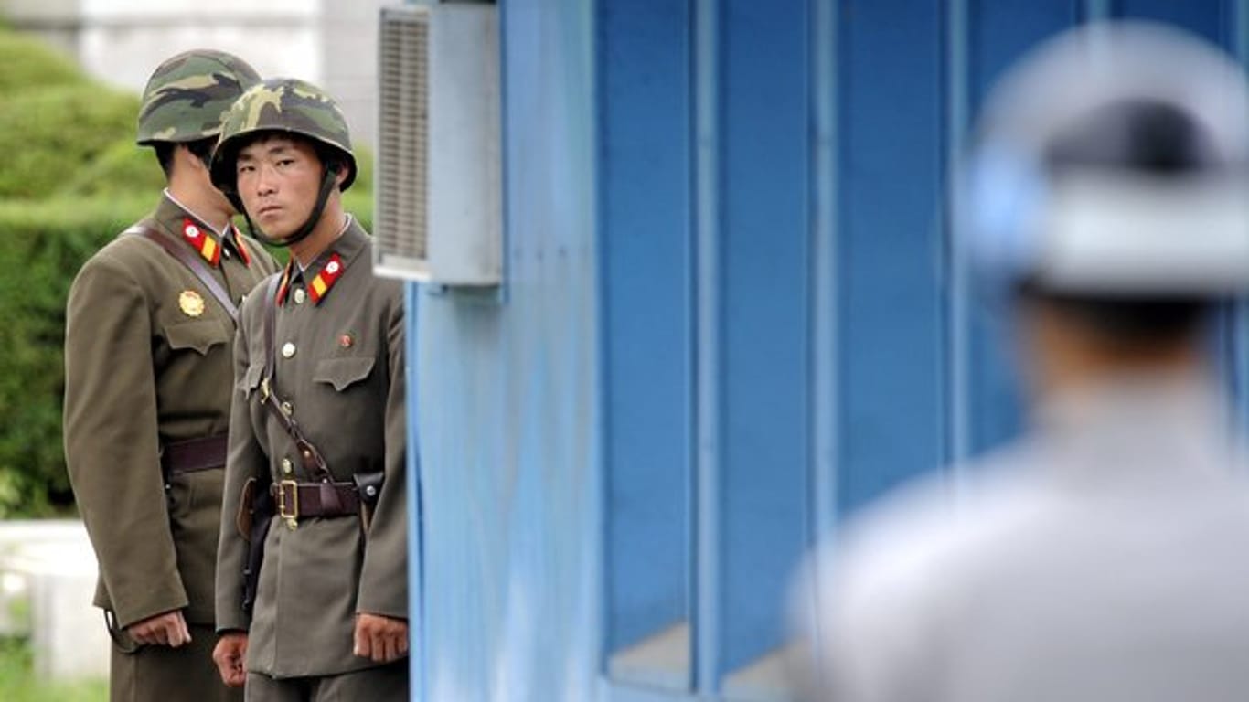 Sichtkontakt: Nordkoreanische Soldaten (im Hintergrund) beobachten im Grenzort Panmunjom einen südkoreanischen Militärangehörigen.